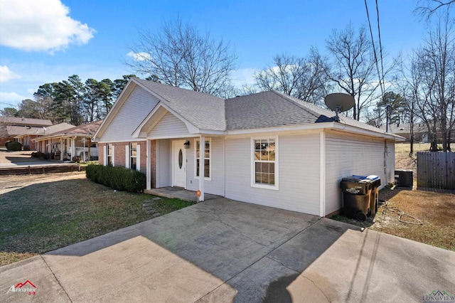 ranch-style home featuring cooling unit and a front lawn