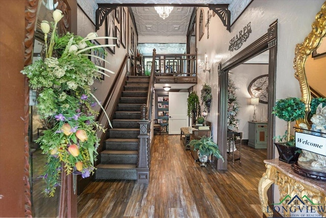 stairway with wood finished floors and an ornate ceiling