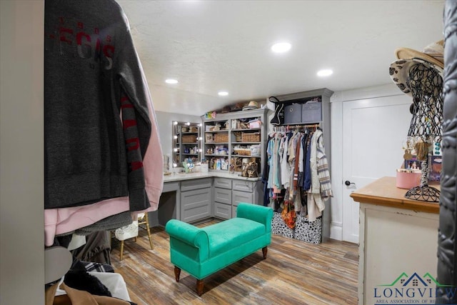 walk in closet featuring wood finished floors and built in study area