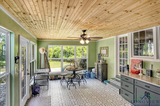 sunroom featuring crown molding, ceiling fan, tile patterned floors, plenty of natural light, and wood ceiling