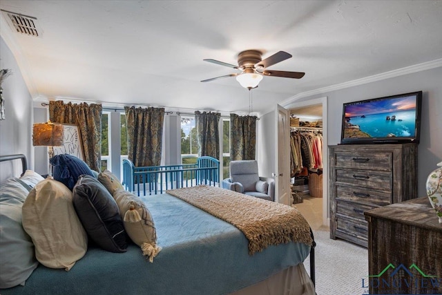 bedroom with light carpet, ornamental molding, a walk in closet, a ceiling fan, and a closet