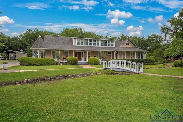 view of front facade featuring a porch, a front yard, and roof with shingles