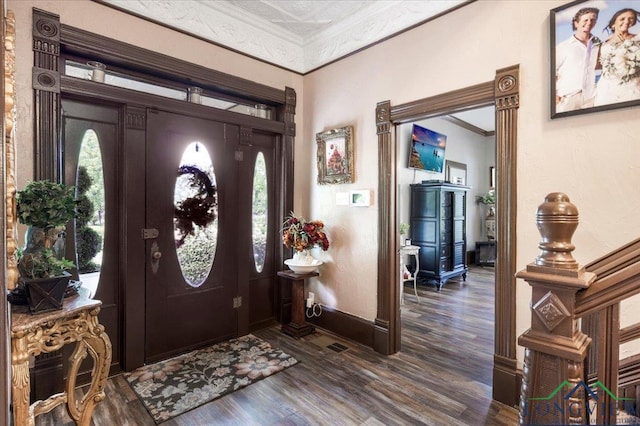 foyer with crown molding, dark wood-type flooring, and baseboards