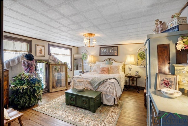 bedroom featuring light wood-type flooring and a chandelier