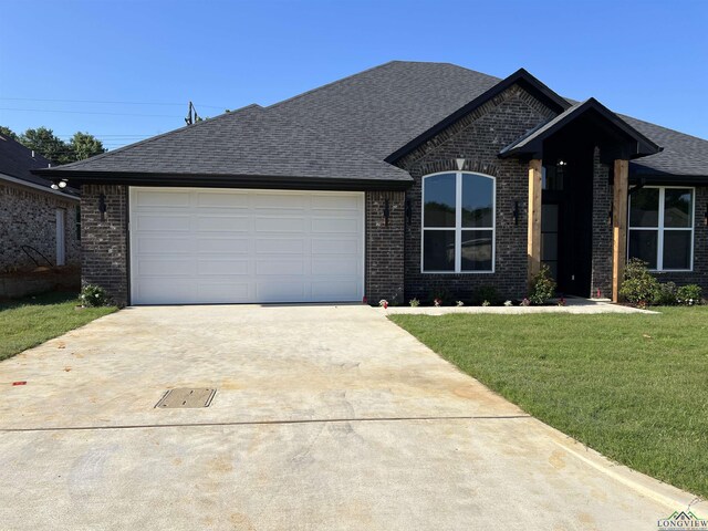 2510 Windmill Ln, Longview, TX 75601 - view of front of home featuring driveway, brick siding, a garage, a front lawn, and a shingled roof
