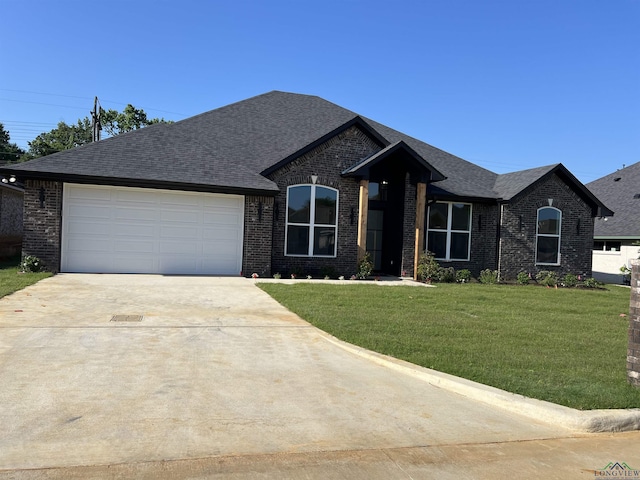 2510 Windmill Ln, Longview, TX 75601 - view of front of house with concrete driveway, an attached garage, brick siding, and a front lawn