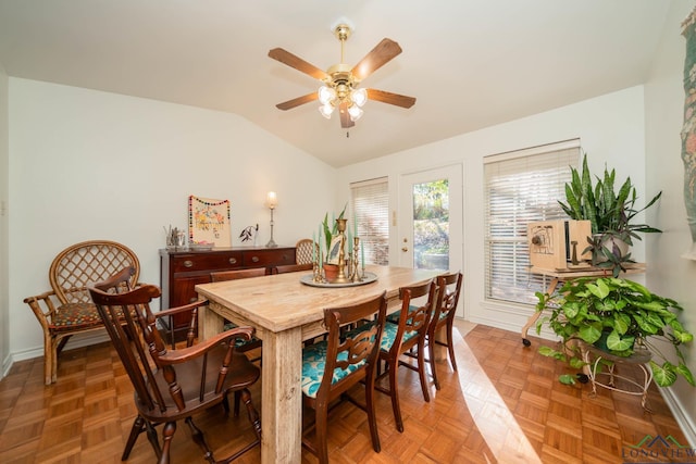 dining space featuring lofted ceiling, ceiling fan, and parquet flooring