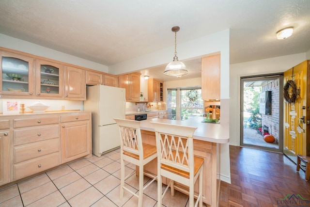 kitchen with sink, white fridge, pendant lighting, a textured ceiling, and light brown cabinetry