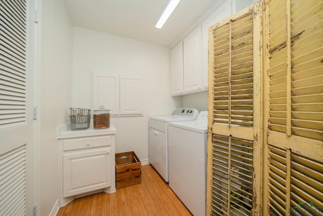 washroom featuring cabinets, light wood-type flooring, and washing machine and dryer