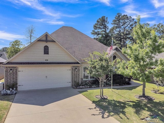 view of front facade with a garage, a front lawn, roof with shingles, and concrete driveway