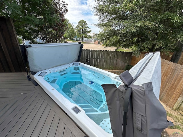 view of swimming pool with a covered hot tub and a fenced backyard
