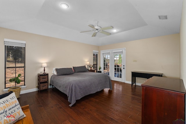 bedroom with access to exterior, dark hardwood / wood-style floors, a raised ceiling, and ceiling fan