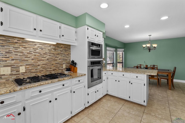 kitchen featuring white cabinetry, stainless steel appliances, backsplash, kitchen peninsula, and a chandelier