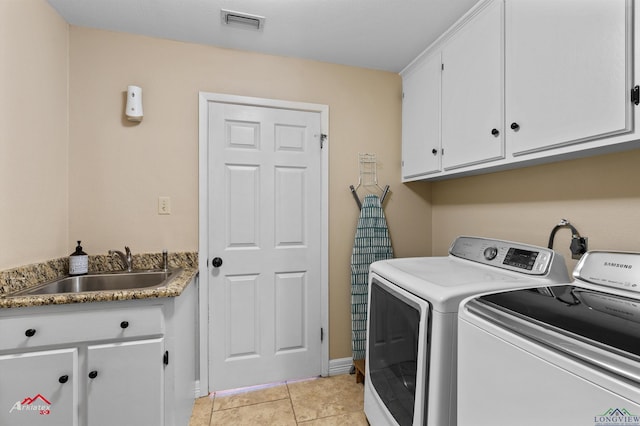 washroom with light tile patterned flooring, cabinets, independent washer and dryer, and sink