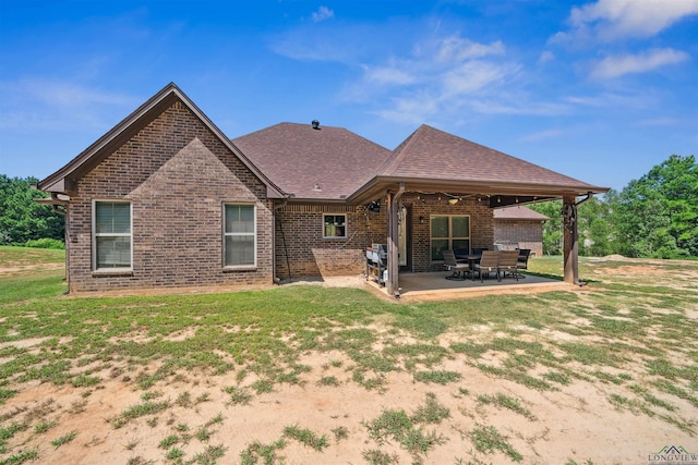 rear view of property featuring a patio and a lawn