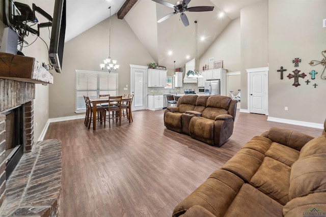 living room featuring a fireplace, hardwood / wood-style floors, ceiling fan with notable chandelier, and high vaulted ceiling