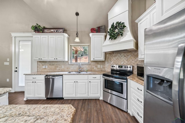 kitchen with white cabinetry, hanging light fixtures, stainless steel appliances, premium range hood, and lofted ceiling