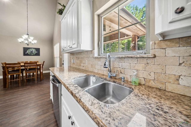 kitchen with white cabinets, sink, hanging light fixtures, stainless steel dishwasher, and light stone countertops