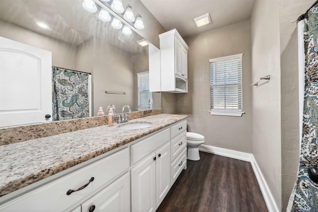 bathroom with toilet, vanity, and hardwood / wood-style flooring