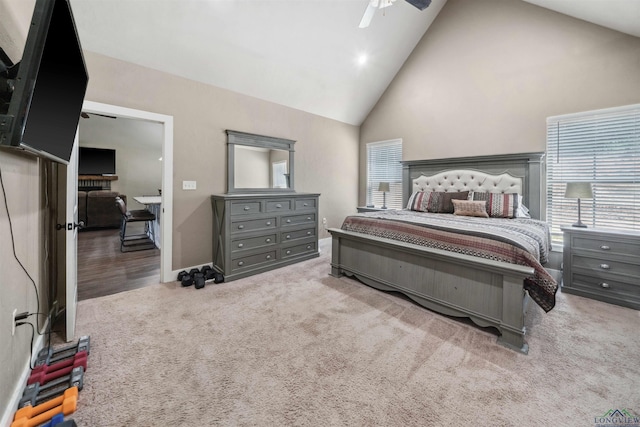 carpeted bedroom with high vaulted ceiling and ceiling fan