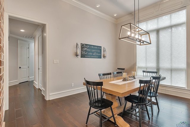 dining space with crown molding, dark wood-type flooring, and an inviting chandelier