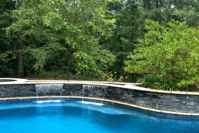 view of swimming pool with pool water feature