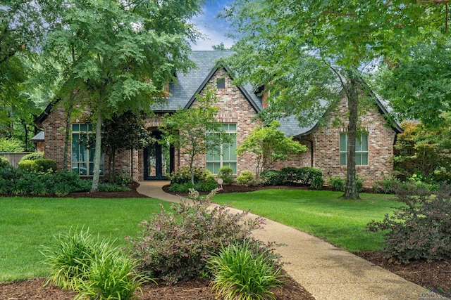 english style home featuring a front lawn