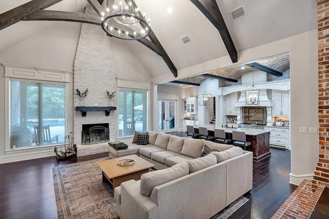 living room with beamed ceiling, high vaulted ceiling, a stone fireplace, and dark wood-type flooring