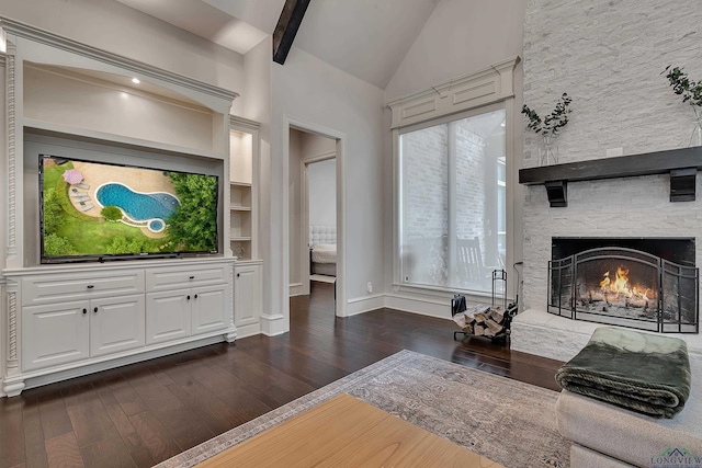 living room featuring a fireplace, built in shelves, vaulted ceiling with beams, and dark wood-type flooring