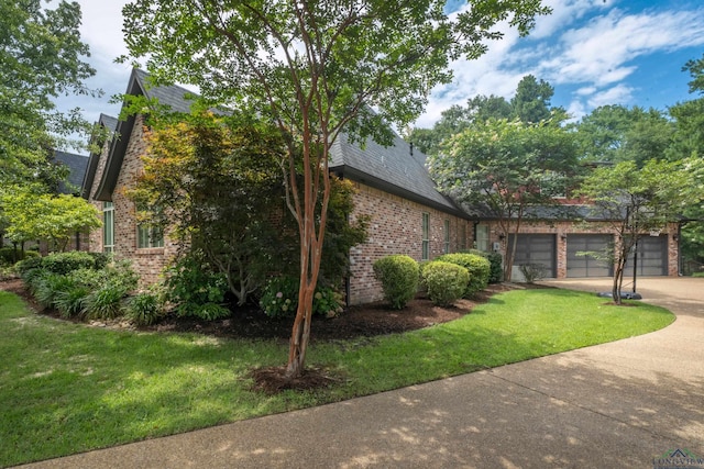 view of side of property featuring a garage and a yard