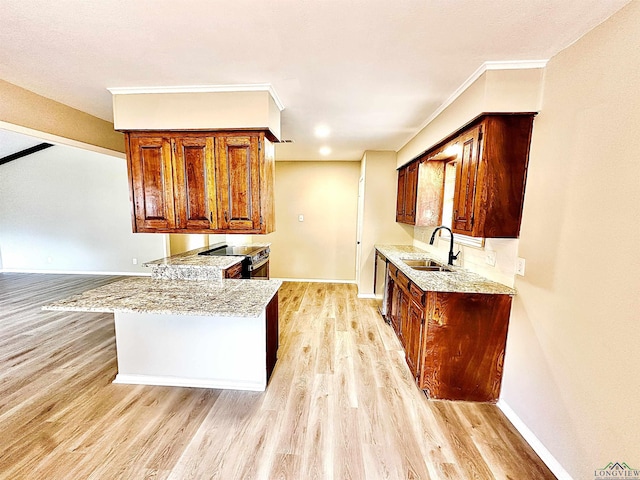 kitchen featuring light stone countertops, sink, light hardwood / wood-style floors, and kitchen peninsula