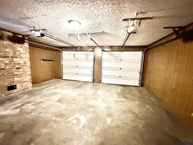 garage with a garage door opener and wooden walls