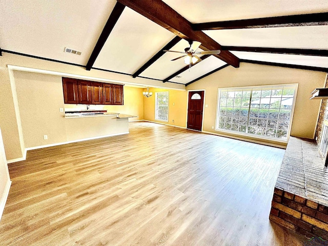 unfurnished living room featuring vaulted ceiling with beams, ceiling fan with notable chandelier, light hardwood / wood-style floors, and a brick fireplace