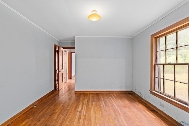 empty room featuring hardwood / wood-style floors and ornamental molding