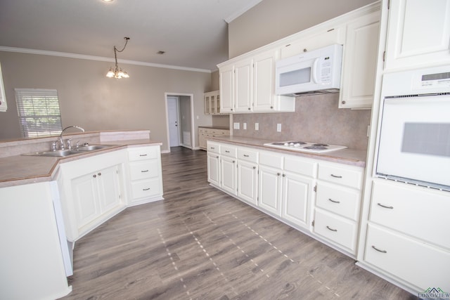 kitchen with pendant lighting, white appliances, ornamental molding, a notable chandelier, and white cabinetry