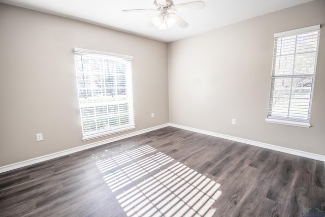 empty room with dark hardwood / wood-style flooring, plenty of natural light, and ceiling fan