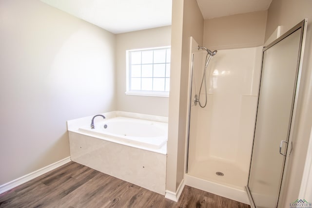 bathroom featuring wood-type flooring and shower with separate bathtub