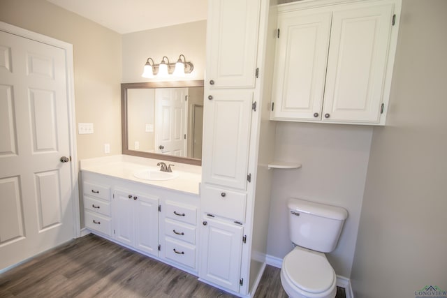 bathroom featuring vanity, hardwood / wood-style flooring, and toilet