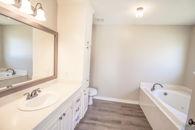 bathroom with hardwood / wood-style floors, vanity, a relaxing tiled tub, and toilet