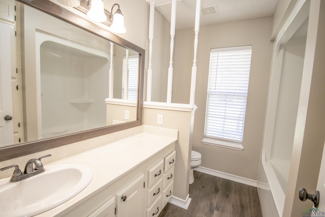 bathroom featuring walk in shower, vanity, wood-type flooring, and toilet