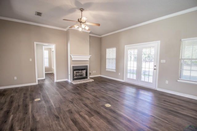 unfurnished living room with dark wood-type flooring, plenty of natural light, ceiling fan, and ornamental molding