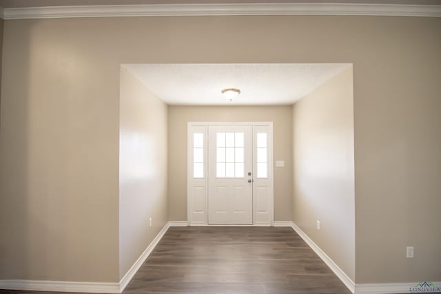 entryway with dark hardwood / wood-style flooring, ornamental molding, and a textured ceiling