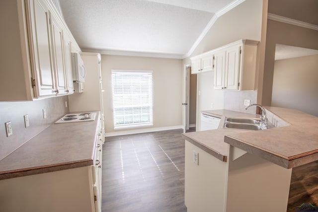 kitchen with kitchen peninsula, ornamental molding, sink, white cabinets, and lofted ceiling