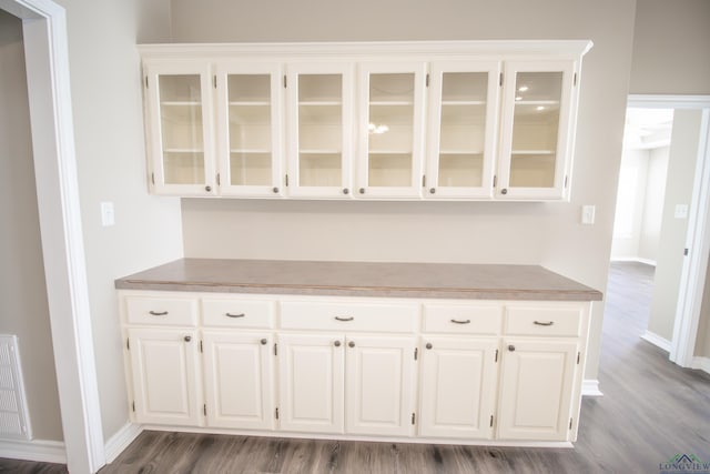 bar featuring white cabinets and hardwood / wood-style flooring