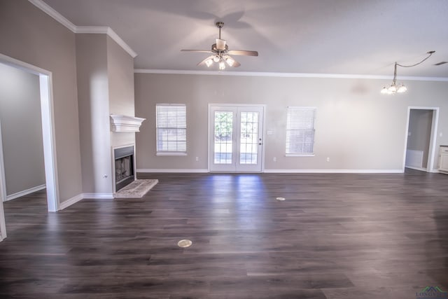 unfurnished living room with ceiling fan with notable chandelier, ornamental molding, and dark wood-type flooring