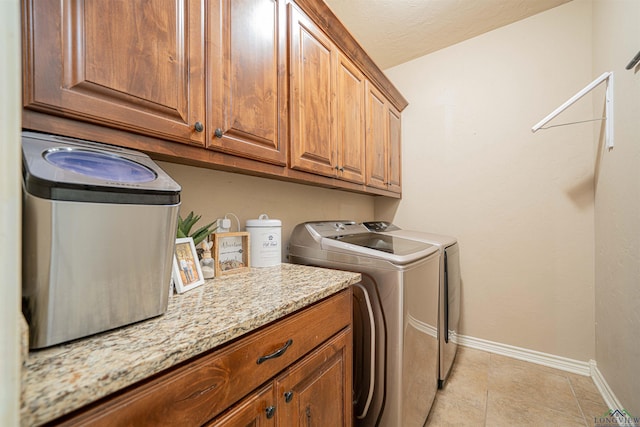 laundry area featuring cabinets, separate washer and dryer, and light tile patterned floors