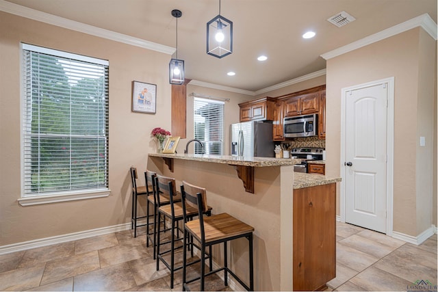 kitchen with pendant lighting, a kitchen breakfast bar, light stone countertops, appliances with stainless steel finishes, and kitchen peninsula