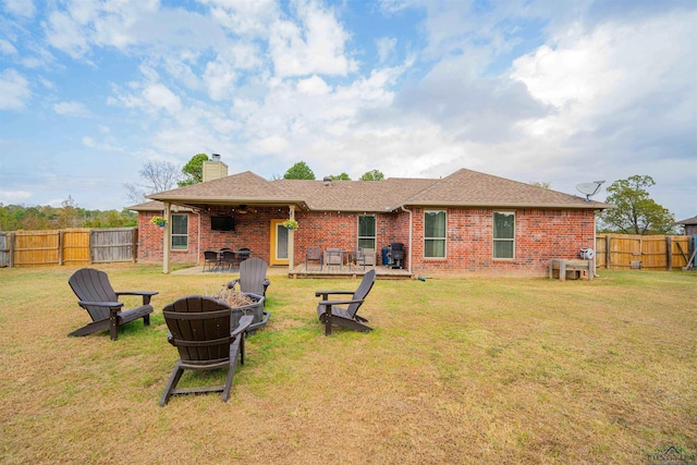 rear view of house with a fire pit, a yard, and a wooden deck