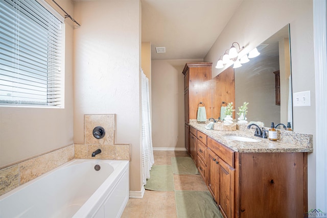 bathroom with a tub, tile patterned flooring, and vanity