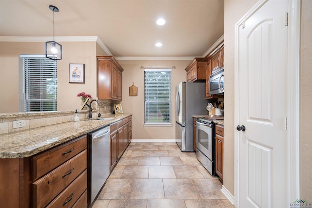 kitchen featuring pendant lighting, sink, crown molding, light stone countertops, and stainless steel appliances